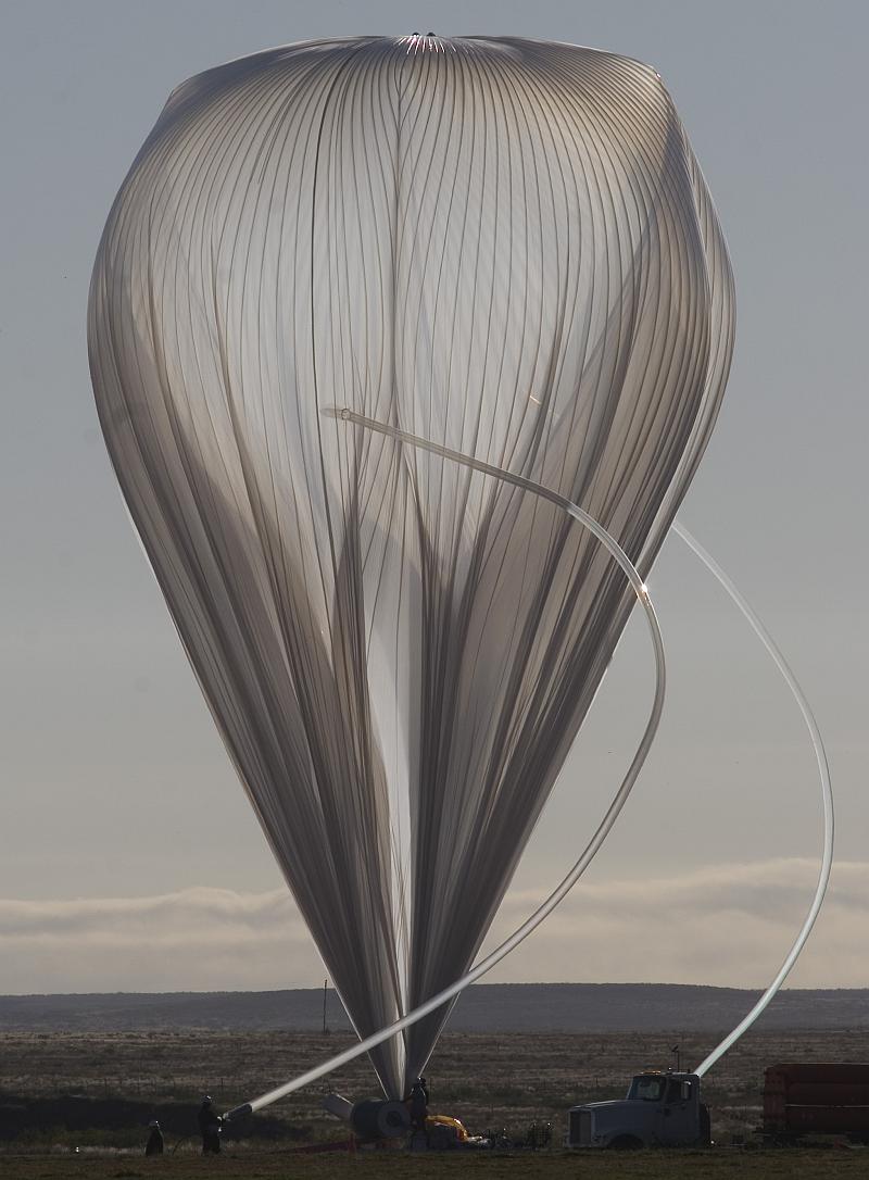 View of the balloon while being inflated. The inflation tubes are curved by effect of the strong wind (Photo by Carlye Calvin, UCAR)